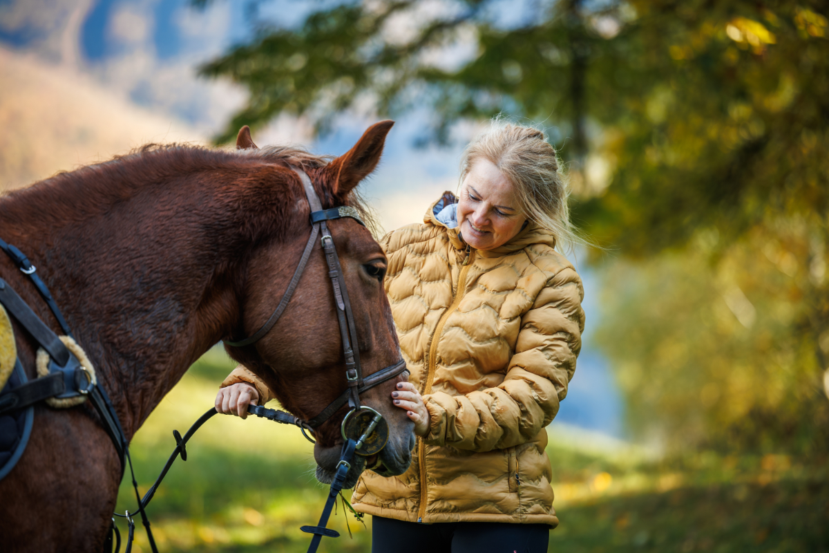 Seniorin streichelt ein ruhiges Pferd